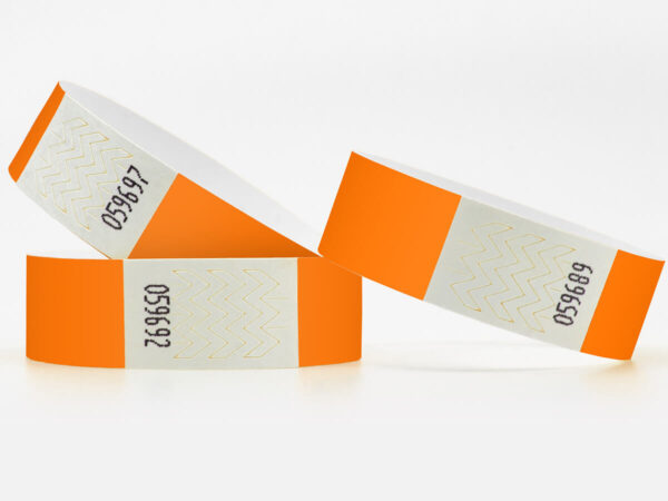 Orangefarbene Tyvek-Kontrollbänder mit fortlaufender Nummerierung. Einlassbänder mit sicherem Klebeverschluss. Hersteller AMGS Group.