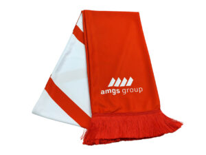 Zweifarbiger Werbeschal der AMGS Group mit markantem Logo und dichten Fransen, gefaltet präsentiert.