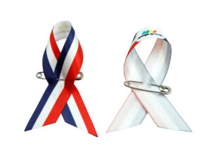 Set aus Satin-Schleifen Awareness Pins in Tricolor und Weiß-Rot, einseitig bedruckt, Hersteller AMGS Group.