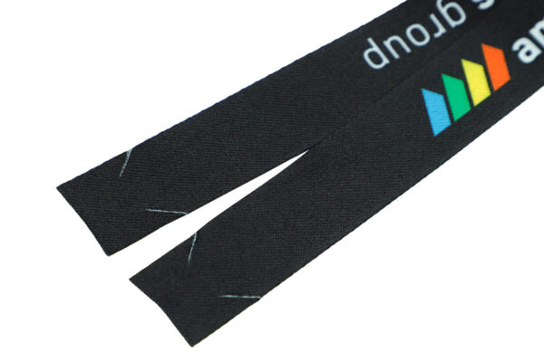 Ein langer, flacher Streifen bedruckten Polyesterbands, bereit zur Montage zu einem individuellen, hakenlosen Werbe-Lanyard.